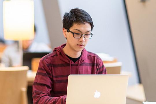 A student working on a computer preparing for a career in computer science.