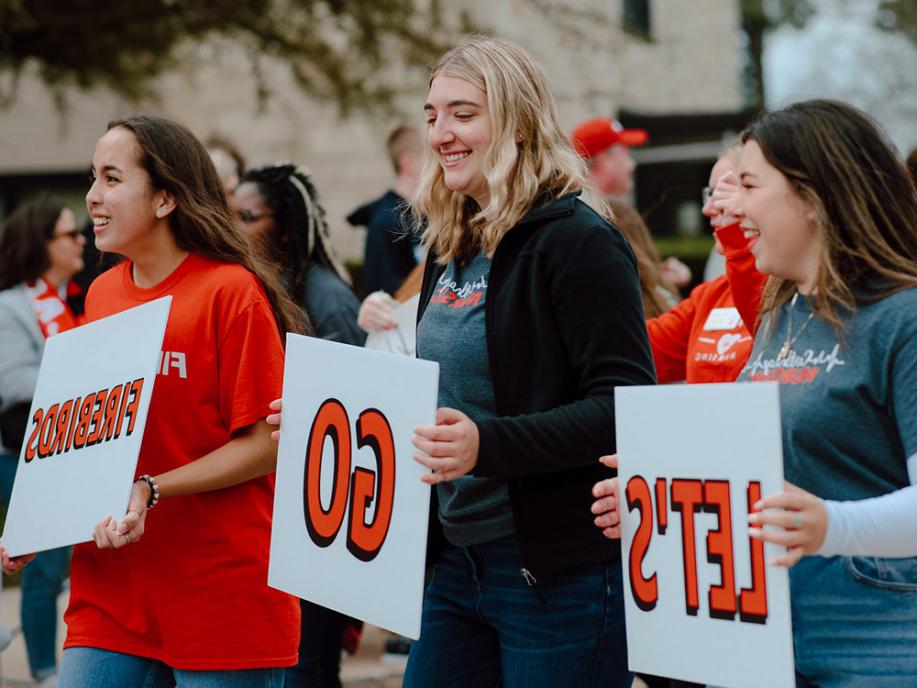 ?Let's Go, Firebirds!? Students walk in the Homecoming Parade.